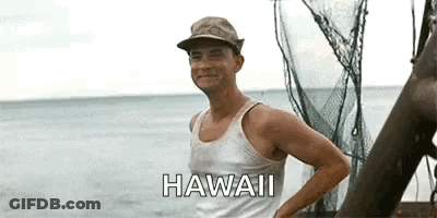 A Man Wearing A Hat And A Tank Top Is Standing On A Boat Near The Ocean . GIF