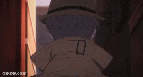 A Man Wearing A Hat And A Trench Coat Has The Letter O On The Collar GIF