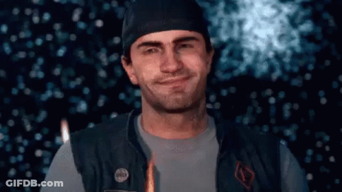 A Man Wearing A Hat And A Vest Is Smiling In Front Of A Firework Display . GIF