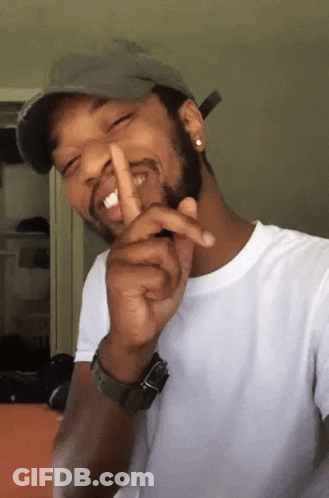 A Man Wearing A Hat And A Watch Is Making A Shhh Gesture GIF