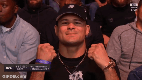A Man Wearing A Hat And A Watch Is Sitting In A Crowd Watching Ufc GIF