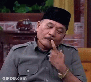 A Man Wearing A Hat And A Watch Is Sitting On A Couch With His Finger In His Mouth . GIF