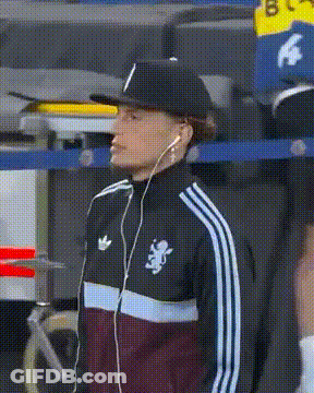 A Man Wearing A Hat And Earbuds Is Wearing An Adidas Jacket GIF