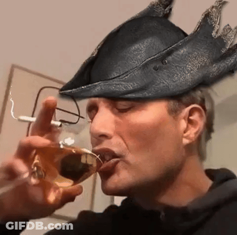 A Man Wearing A Hat And Glasses Is Drinking From A Wine Glass . GIF
