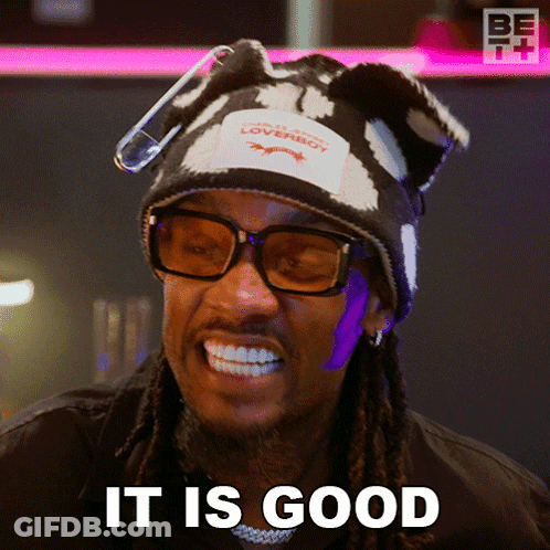 A Man Wearing A Hat And Glasses Is Smiling And Says It Is Good GIF