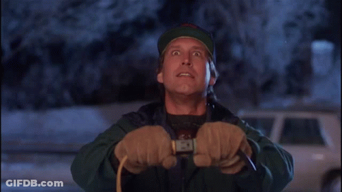 A Man Wearing A Hat And Gloves Is Holding A Rope And Looking Up GIF