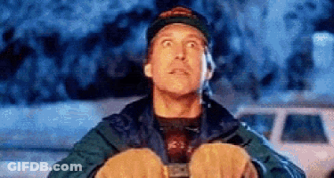 A Man Wearing A Hat And Gloves Is Looking Up At The Sky While Holding Something In His Hands . GIF