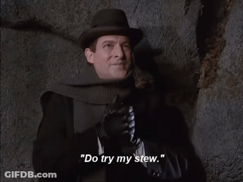 A Man Wearing A Hat And Gloves Says " Rubs Hands With Anticipation " GIF