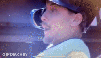 A Man Wearing A Hat And Goggles Is Looking At Something . GIF