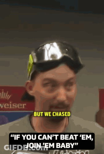 A Man Wearing A Hat And Goggles Says " If You Can 'T Beat ' Em Join ' Em Baby " GIF