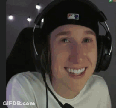 A Man Wearing A Hat And Headphones Is Smiling . GIF