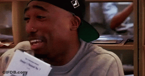 A Man Wearing A Hat And Holding A Piece Of Paper In His Hand . GIF