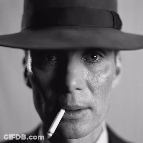 A Man Wearing A Hat And Smoking A Cigarette In A Black And White Photo . GIF
