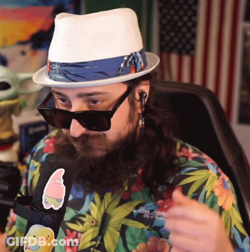 A Man Wearing A Hat And Sunglasses Has A Sticker On His Shirt That Says Spongebob GIF