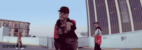 A Man Wearing A Hat And Sunglasses Is Pointing GIF