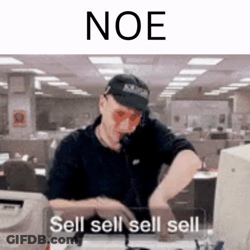 A Man Wearing A Hat And Sunglasses Is Sitting At A Desk Talking On A Cell Phone . GIF