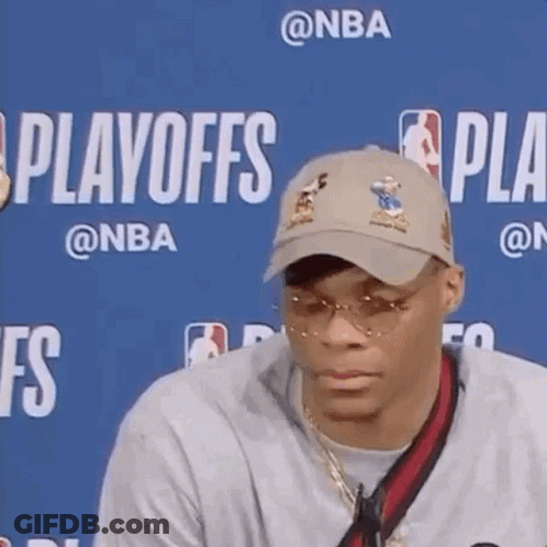 A Man Wearing A Hat And Sunglasses Is Sitting In Front Of A Blue Background With The Word Playoffs On It . GIF