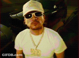 A Man Wearing A Hat And Sunglasses Is Standing In Front Of A Car .. GIF