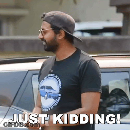 A Man Wearing A Hat And Sunglasses Is Standing In Front Of A Car And Says Just Kidding ! GIF