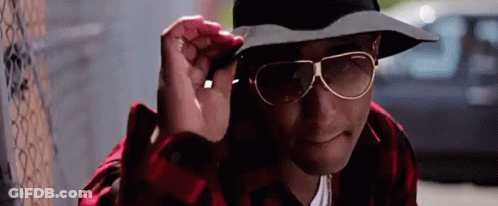 Man With Hat And Sunglasses Next To Fence GIF