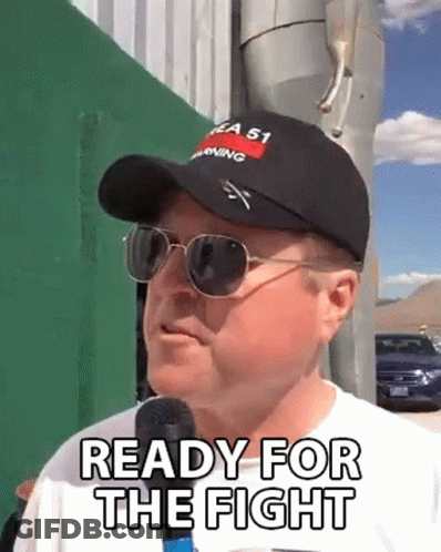 A Man Wearing A Hat And Sunglasses Is Talking Into A Microphone And Saying Ready For The Fight . GIF