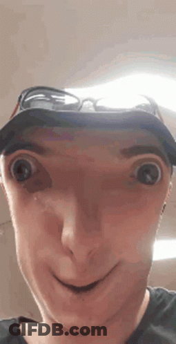 A Man Wearing A Hat And Sunglasses Making A Funny Face . GIF