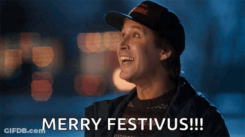 A Man Wearing A Hat And Sweater Says Merry Festivus !!! GIF
