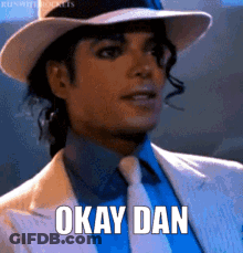 A Man Wearing A Hat And Tie Is Saying Okay Dan GIF
