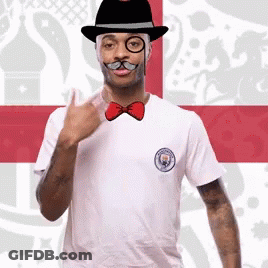 A Man Wearing A Hat Glasses And A Bow Tie GIF