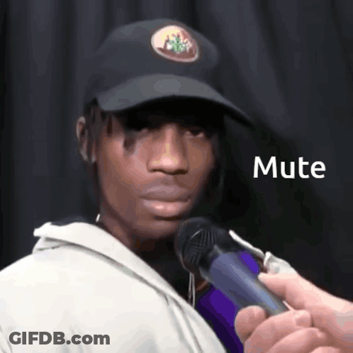 A Man Wearing A Hat Is Being Interviewed By A Person Holding A Microphone That Says Mute GIF