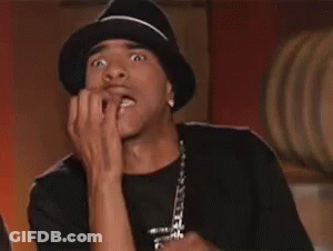 A Man Wearing A Hat Is Biting His Nails And Making A Funny Face . GIF