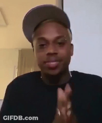 A Man Wearing A Hat Is Clapping His Hands . GIF