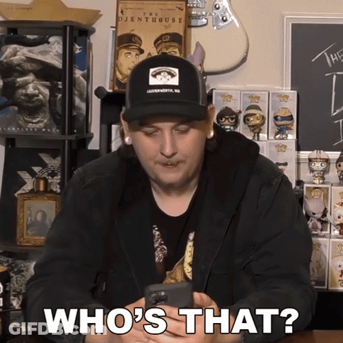 A Man Wearing A Hat Is Holding A Phone And Says Who 'S That GIF