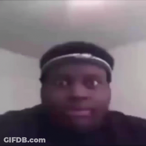 A Man Wearing A Hat Is Making A Funny Face In A Room . GIF