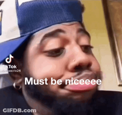 A Man Wearing A Hat Is Making A Funny Face With His Tongue Out . GIF