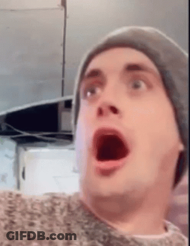 A Man Wearing A Hat Is Making A Surprised Face . GIF