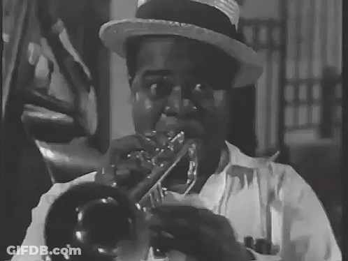 A Man Wearing A Hat Is Playing A Trumpet In A Black And White Photo GIF