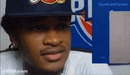 A Man Wearing A Hat Is Sitting In Front Of A Sign That Says ' Sound And Screen ' GIF