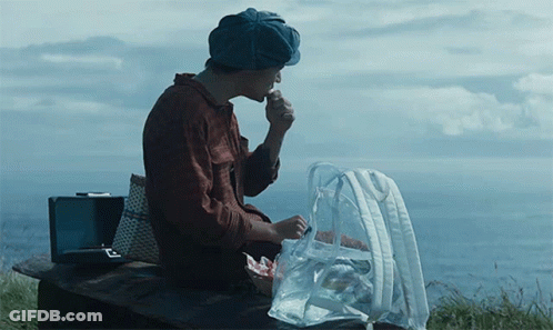 Man In Hat Sitting On Bench With Food Bag GIF