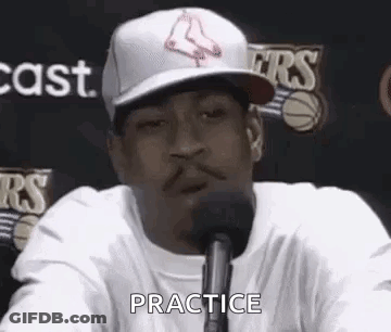 A Man Wearing A Hat Is Talking Into A Microphone And Saying `` Practice '' . GIF