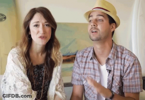 A Man Wearing A Hat Is Talking To A Woman Who Is Looking At Him GIF