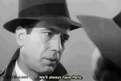 A Man Wearing A Hat Is Talking To Another Man In A Black And White Photo . GIF
