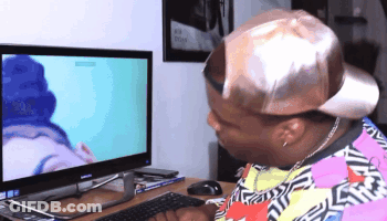 A Man Wearing A Hat Looks At A Computer Monitor GIF