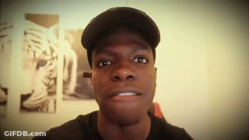 A Man Wearing A Hat Looks At The Camera With A Picture Of A Tiger In The Background GIF