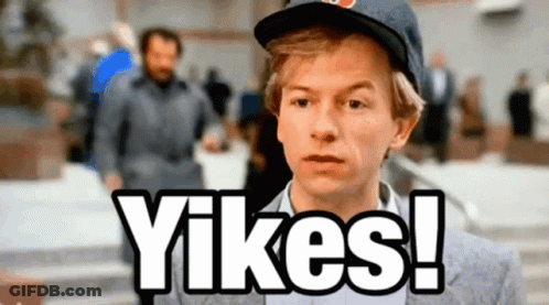 A Man Wearing A Hat Says " Yikes " In Front Of A Crowd GIF