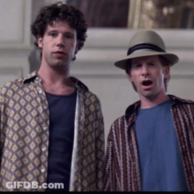 A Man Wearing A Hat Stands Next To Another Man GIF