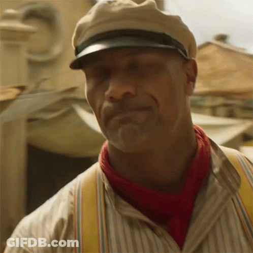A Man Wearing A Hat , Suspenders And A Red Scarf Is Smiling . GIF