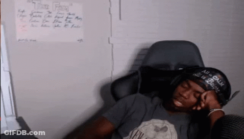 A Man Wearing A Hat That Says " All Is Calm " Is Sleeping In A Chair GIF