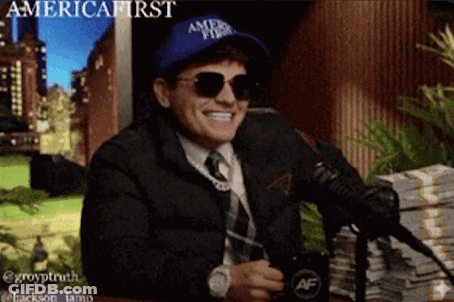 A Man Wearing A Hat That Says America First Is Sitting In Front Of A Microphone GIF