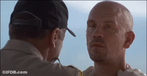 A Man Wearing A Hat That Says Brooklyn Is Touching The Neck Of Another Man GIF
